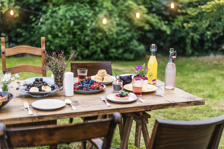 Spring and Summer Entertaining: Culinary Terms & Etiquette Tips | Table Food Lunch Variety Concept Outdoors with fresh fruits and juices