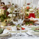 Fall glassware | dining etiquette | A sophisticated tableau arrangement on the table, adorned with candles and delicately placed flowers beneath the play of shadows. A wedding style reminiscent of Provence aesthetics