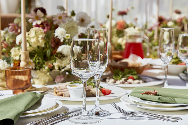 Fall glassware | dining etiquette | A sophisticated tableau arrangement on the table, adorned with candles and delicately placed flowers beneath the play of shadows. A wedding style reminiscent of Provence aesthetics